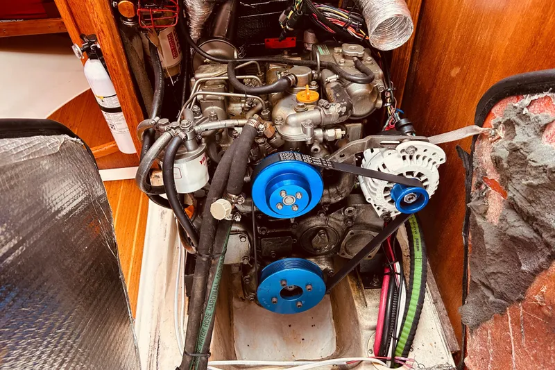 Slide: The Image of Engine compartment of a 2003 Hunter 386 sailboat, featuring visible belts and wiring. - 42