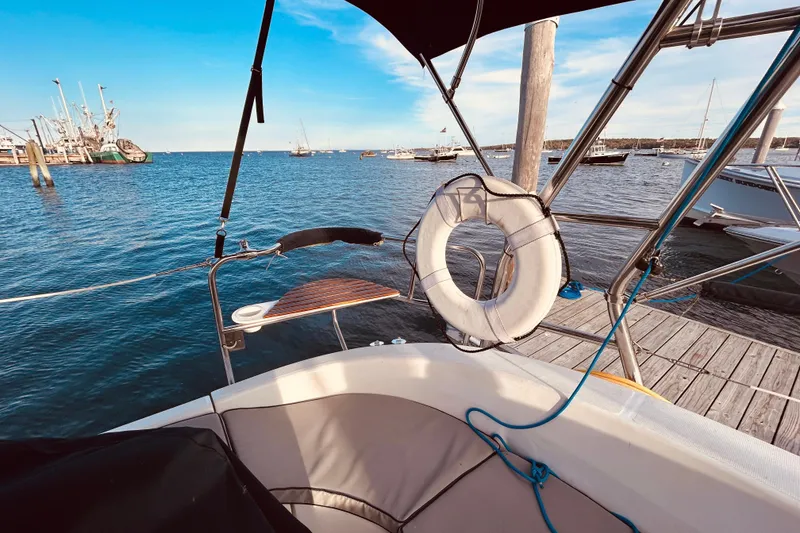Slide: The Image of Hunter 386 sailboat docked at marina, featuring lifebuoy and scenic ocean view, 2003 model. - 8