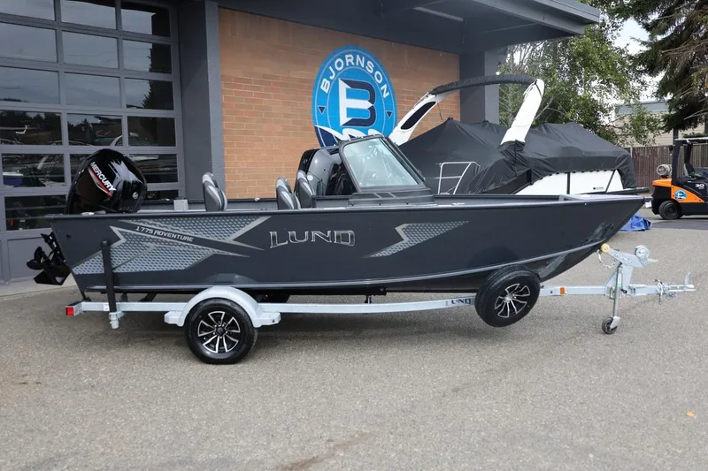 Slide: The Image of 2026 Lund 1775 Adventure Sport boat on trailer, parked outside dealership. - 1