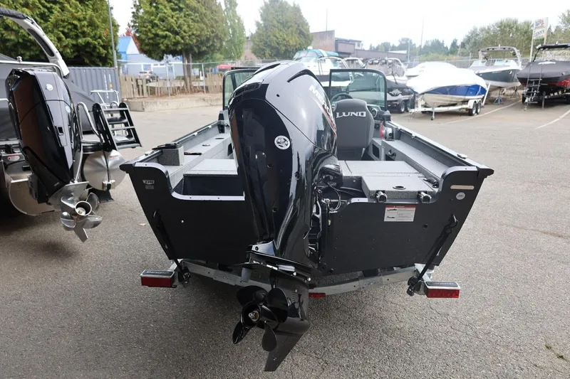 Slide: The Image of 2026 Lund 1775 Adventure Sport boat with powerful outboard motor, parked in a marina. - 11