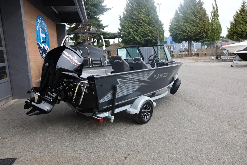 Slide: The Image of 2026 Lund 1775 Adventure Sport boat with Mercury engine on trailer, parked outdoors. - 14