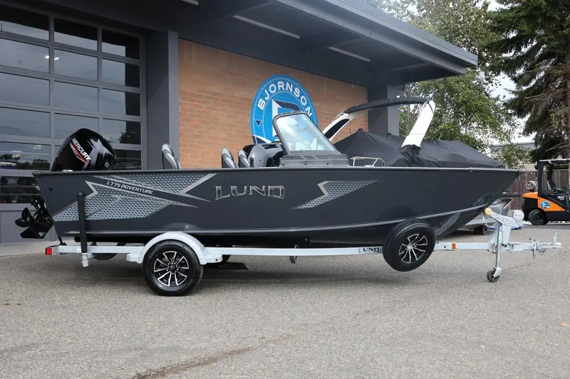 Slide: The Image of 2026 Lund 1775 Adventure Sport boat on trailer outside dealership. - 2