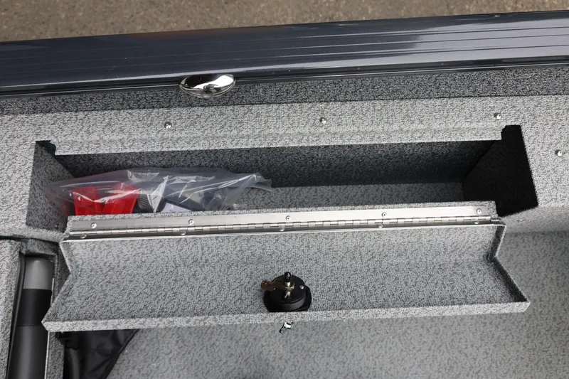 Slide: The Image of Storage compartment in 2026 Lund 1775 Adventure Sport boat, featuring secure latch and organized space. - 23