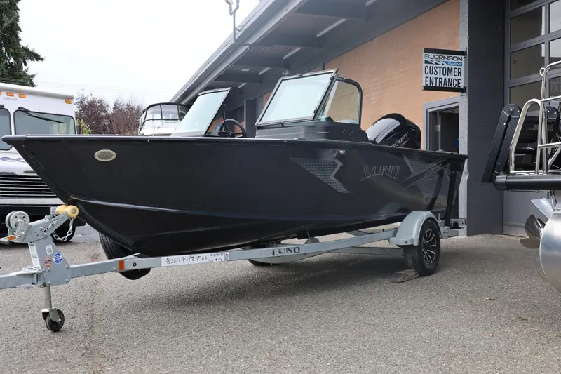Slide: The Image of 2026 Lund 1775 Adventure Sport boat on trailer outside marine shop. - 8