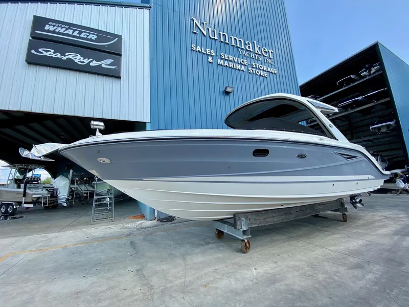 Slide: The Image of 2019 Sea Ray 310 SLX boat displayed at a marina store. - 0