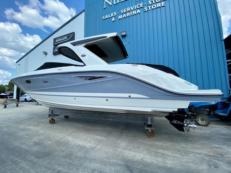 Slide: The Image of 2019 Sea Ray 310 SLX boat displayed outside a marina store. - 1