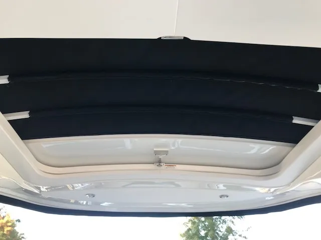 Slide: The Image of 2019 Sea Ray 310 SLX boat interior roof with black retractable sunshade. - 24