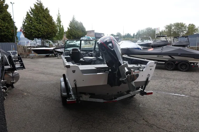 Slide: The Image of 2026 Lund 1875 Impact XS Sport boat in a marina, rear view. - 11
