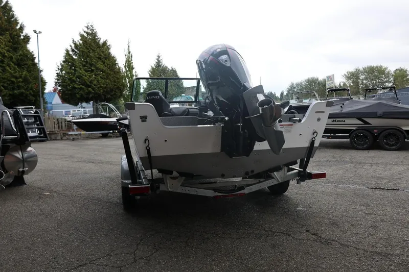 Slide: The Image of 2026 Lund 1875 Impact XS Sport boat on trailer, rear view in outdoor setting. - 12