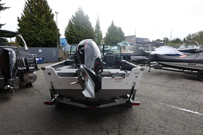 Slide: The Image of 2026 Lund 1875 Impact XS Sport boat with outboard motor in a marina. - 13