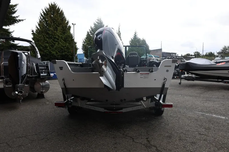 Slide: The Image of 2026 Lund 1875 Impact XS Sport boat on trailer, rear view in outdoor setting. - 14