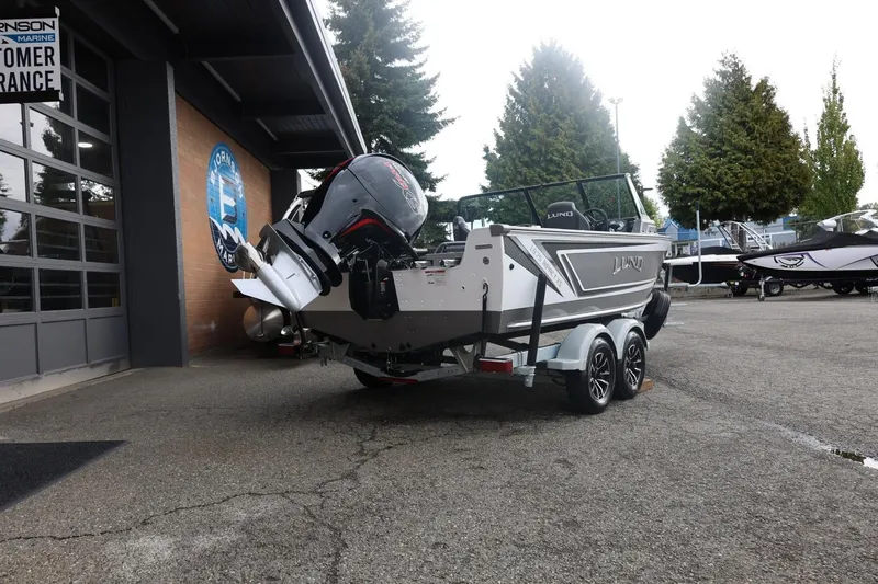 Slide: The Image of 2026 Lund 1875 Impact XS Sport boat on trailer outside dealership. - 16