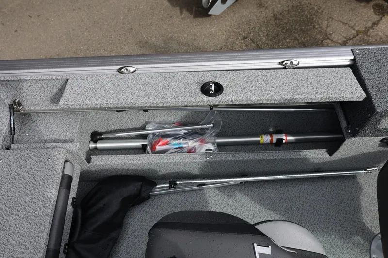 Slide: The Image of Storage compartment of 2026 Lund 1875 Impact XS Sport boat, featuring organized equipment. - 26