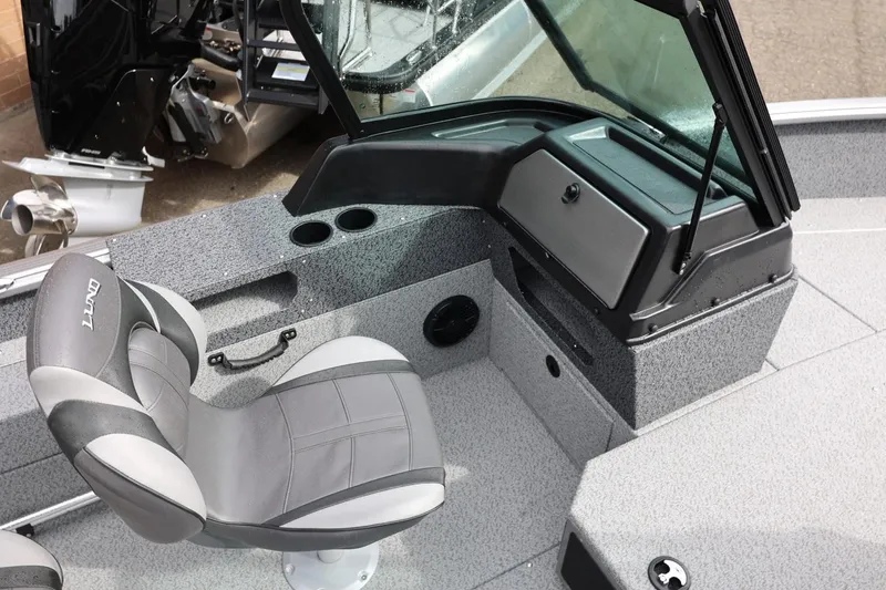 Slide: The Image of 2026 Lund 1875 Impact XS Sport boat interior with gray seating and dashboard. - 27