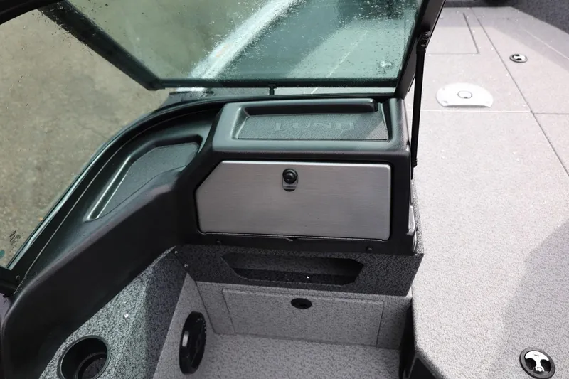 Slide: The Image of 2026 Lund 1875 Impact XS Sport boat interior with storage compartment and windshield. - 28