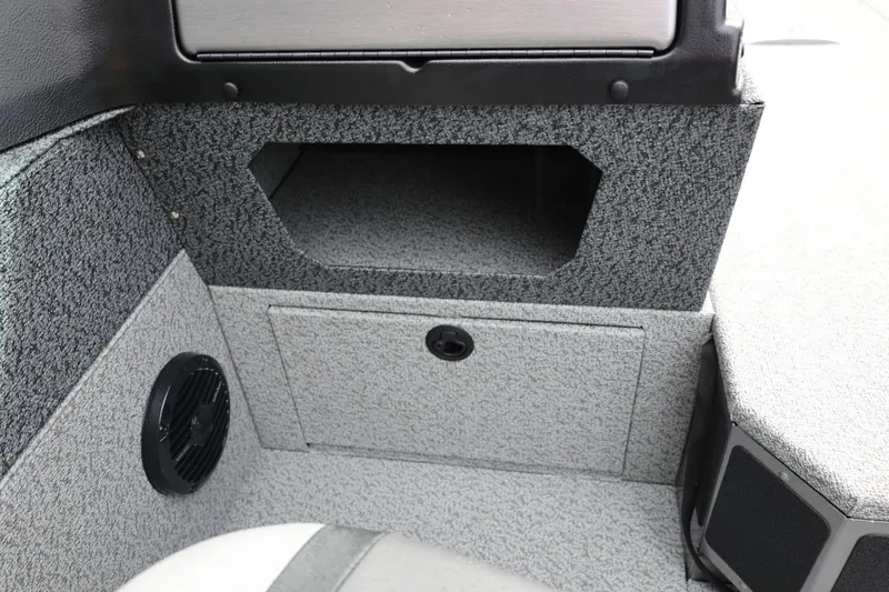 Slide: The Image of Interior of 2026 Lund 1875 Impact XS Sport boat, featuring storage compartment and speaker. - 29