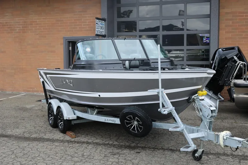 Slide: The Image of 2026 Lund 1875 Impact XS Sport boat on trailer outside a garage. - 3