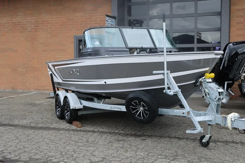 Slide: The Image of 2026 Lund 1875 Impact XS Sport boat on trailer, parked outside a brick building. - 4