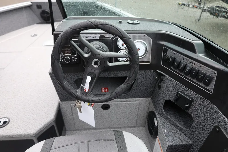 Slide: The Image of 2026 Lund 1875 Impact XS Sport boat dashboard with steering wheel and control panel. - 40