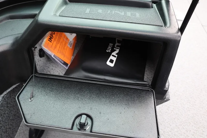 Slide: The Image of Storage compartment of 2026 Lund 1875 Impact XS Sport boat, featuring manuals and accessories. - 44