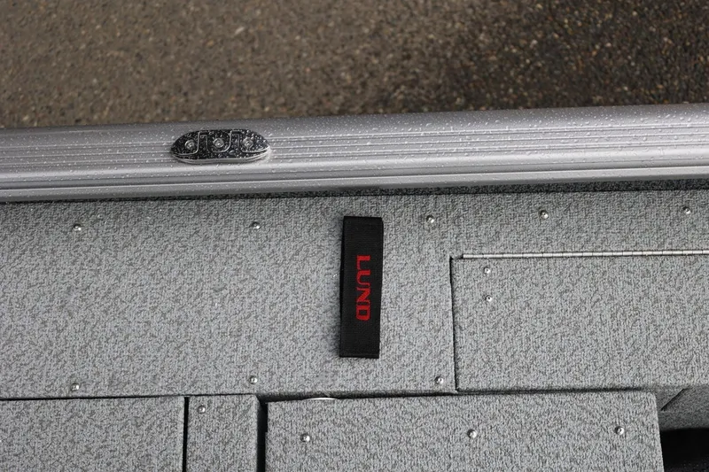 Slide: The Image of 2026 Lund 1875 Impact XS Sport boat interior with textured flooring and logo. - 56