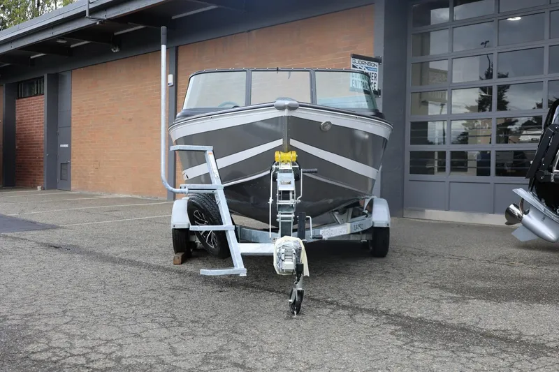 Slide: The Image of 2026 Lund 1875 Impact XS Sport boat on trailer outside a garage. - 6