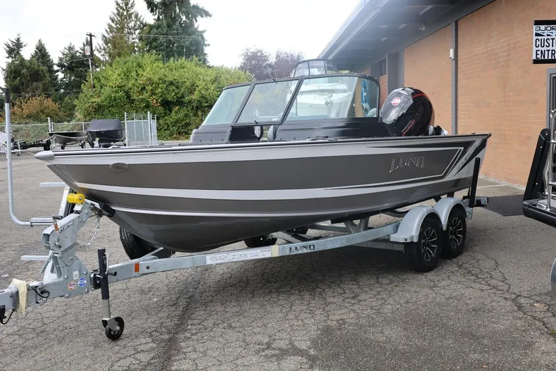 Slide: The Image of 2026 Lund 1875 Impact XS Sport boat on trailer, parked outdoors. - 7