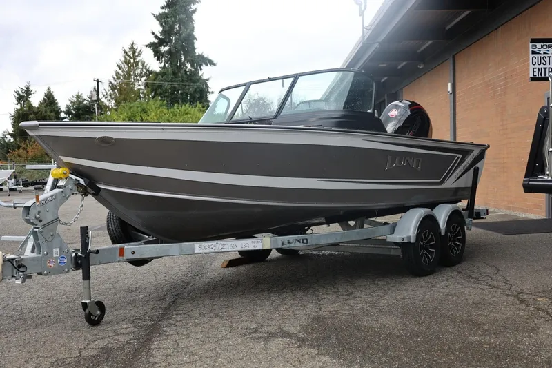 Slide: The Image of 2026 Lund 1875 Impact XS Sport boat on trailer, parked outdoors. - 8