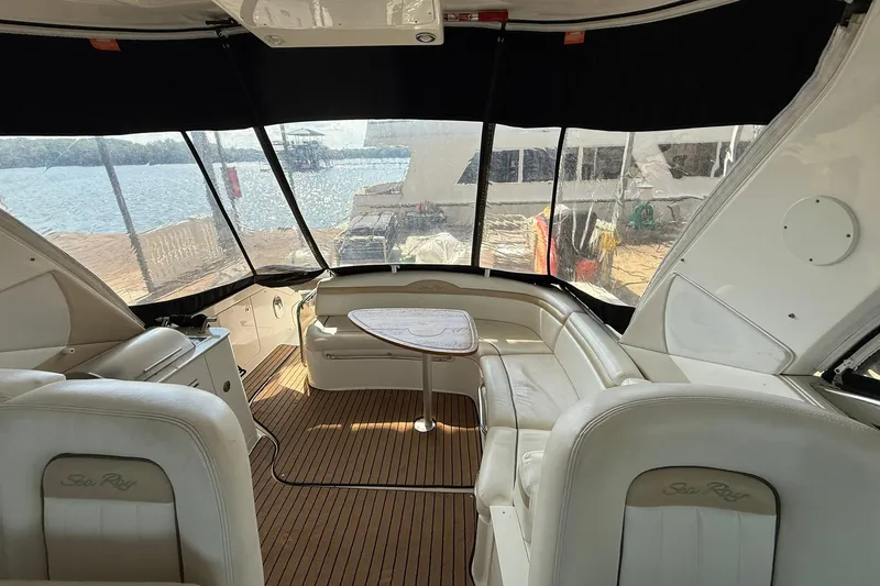 Slide: The Image of Interior of a 2009 Sea Ray 350 Sundancer yacht with white seating and wood flooring. - 13