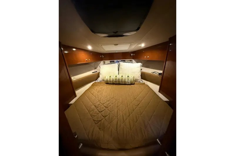 Slide: The Image of Interior cabin of 2009 Sea Ray 350 Sundancer with cozy bed and wooden accents. - 19