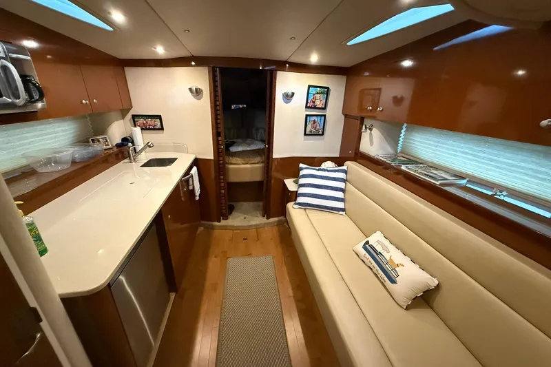 Slide: The Image of Interior of 2009 Sea Ray 350 Sundancer yacht with modern kitchen and cozy seating area. - 21