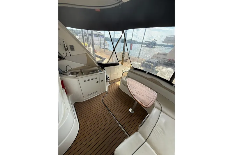 Slide: The Image of Interior of 2009 Sea Ray 350 Sundancer yacht with seating and kitchenette, docked by the water. - 6