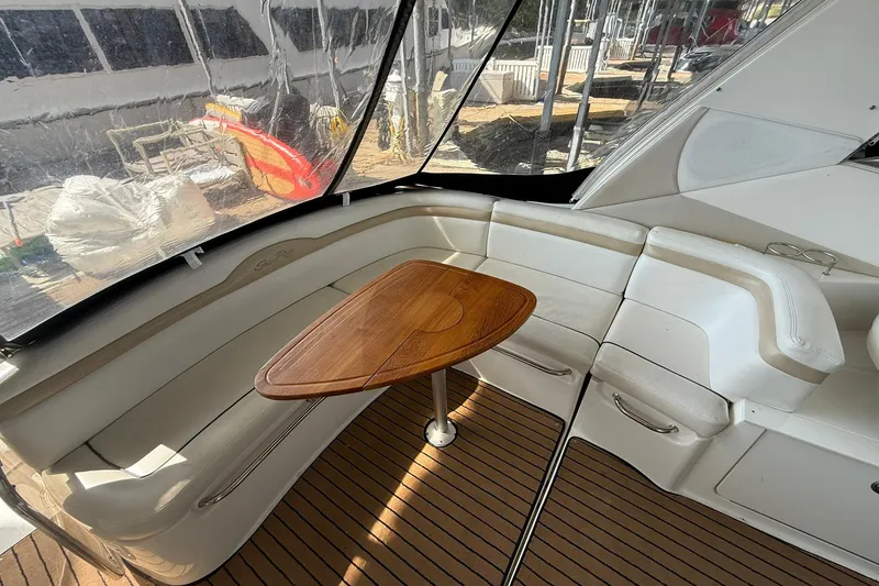 Slide: The Image of Interior of 2009 Sea Ray 350 Sundancer with wooden table and white seating. - 9