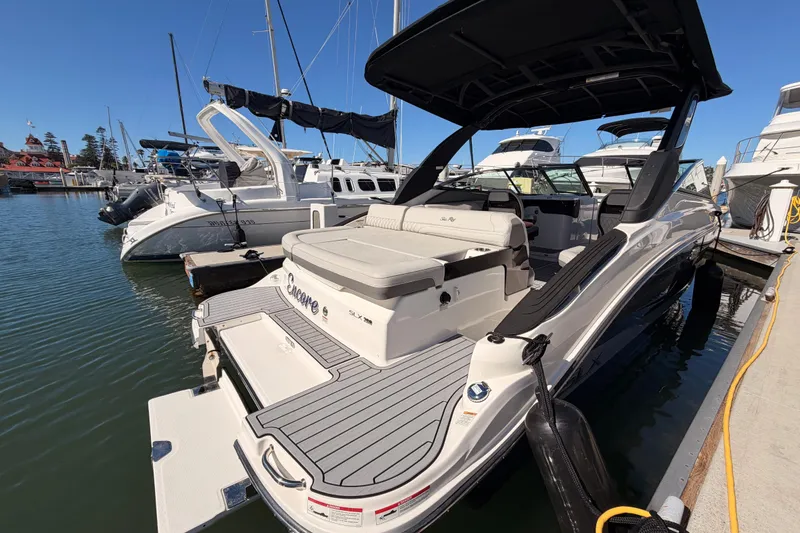 Slide: The Image of 2024 Sea Ray SLX 260 boat docked at marina, featuring sleek design and spacious seating. - 10