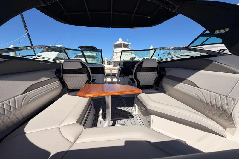 Slide: The Image of 2024 Sea Ray SLX 260 boat interior with luxurious seating and wooden table. - 15