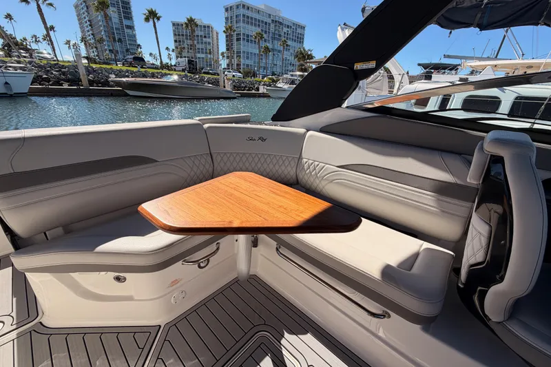 Slide: The Image of Luxurious 2024 Sea Ray SLX 260 boat interior with elegant seating and wooden table. - 19