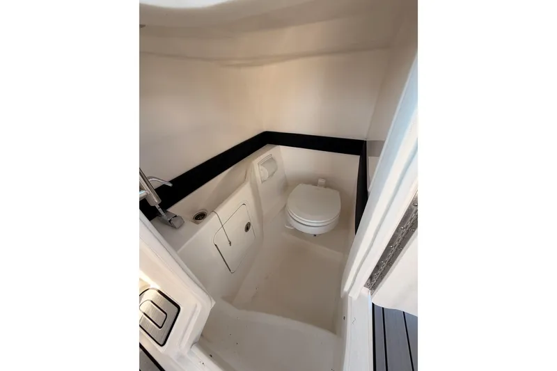 Slide: The Image of 2024 Sea Ray SLX 260 boat interior bathroom with toilet and sink. - 23