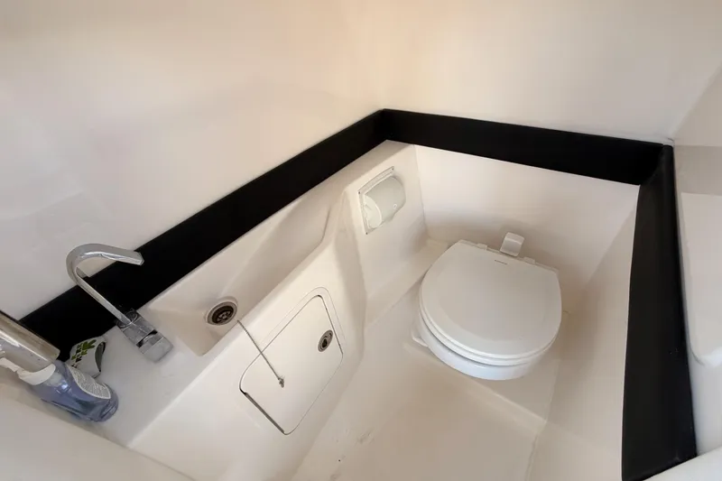 Slide: The Image of 2024 Sea Ray SLX 260 boat bathroom with toilet, sink, and modern fixtures. - 24