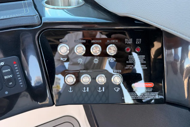 Slide: The Image of 2024 Sea Ray SLX 260 control panel with various switches and warning labels. - 28