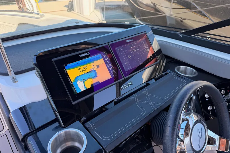 Slide: The Image of 2024 Sea Ray SLX 260 dashboard with dual Simrad displays and steering wheel. - 31