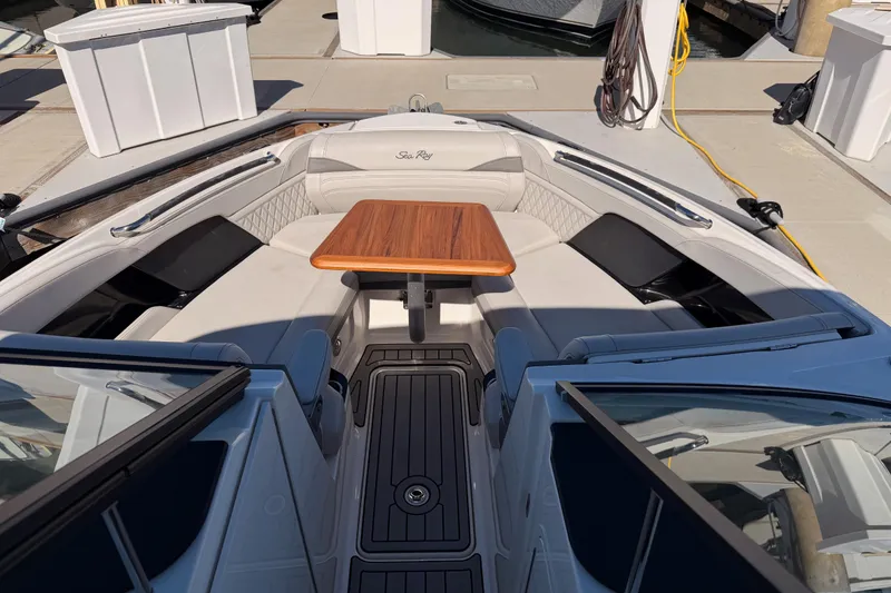 Slide: The Image of 2024 Sea Ray SLX 260 boat interior with elegant seating and wooden table. - 34