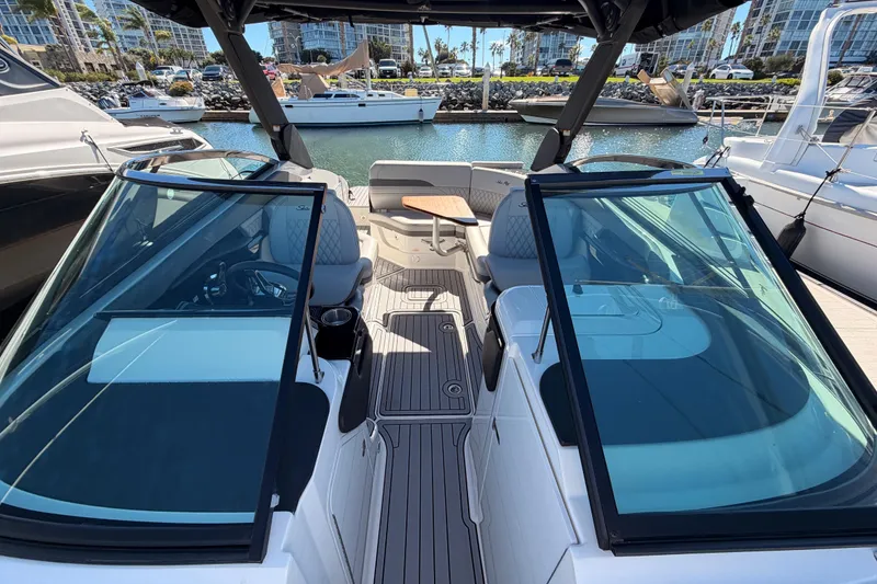 Slide: The Image of 2024 Sea Ray SLX 260 boat interior with modern seating and sleek design in a marina setting. - 38