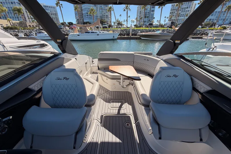 Slide: The Image of 2024 Sea Ray SLX 260 boat interior with luxurious seating and table, docked in marina. - 39