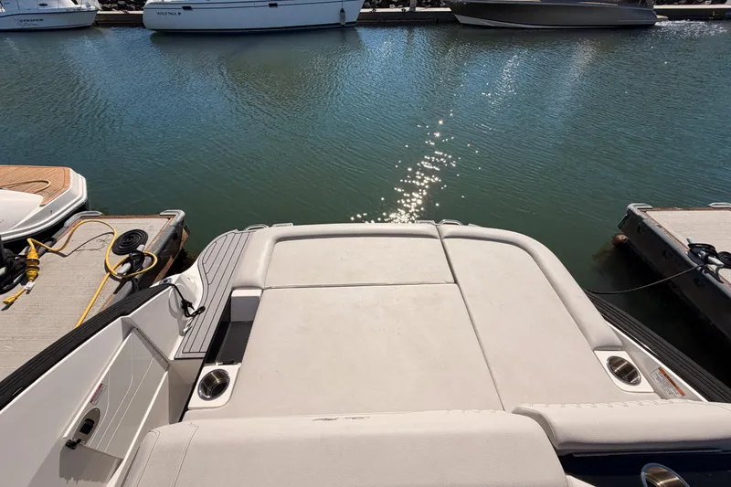 Slide: The Image of 2024 Sea Ray SLX 260 boat docked, showcasing spacious swim platform and serene water view. - 41
