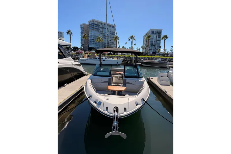 Slide: The Image of 2024 Sea Ray SLX 260 boat docked in marina with modern buildings in background. - 5