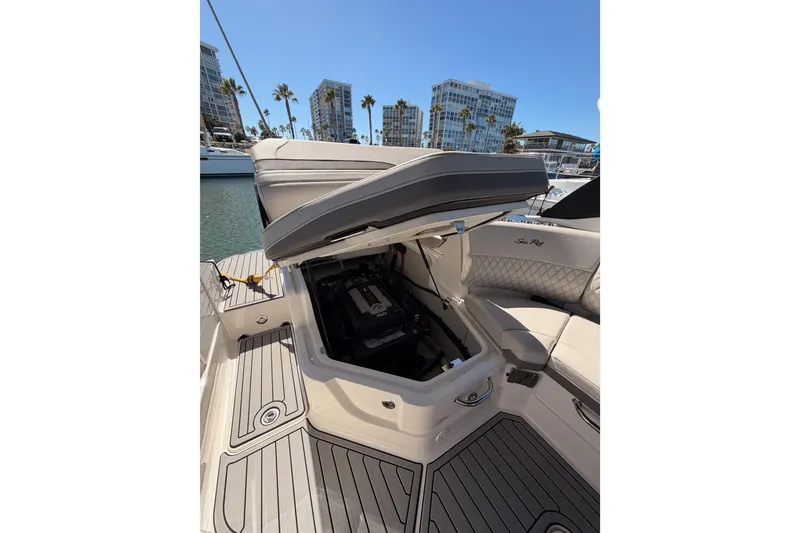 Slide: The Image of 2024 Sea Ray SLX 260 boat with open storage compartment, docked near modern buildings. - 50