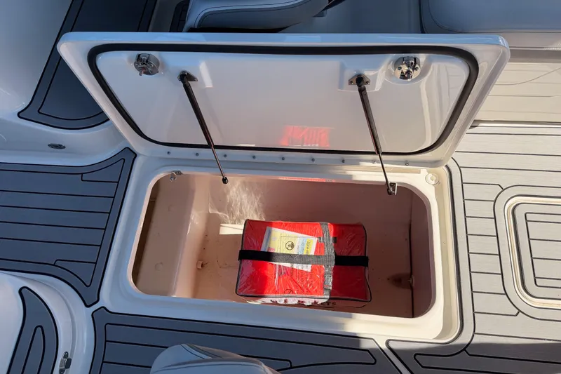 Slide: The Image of 2024 Sea Ray SLX 260 storage compartment with safety equipment inside. - 52
