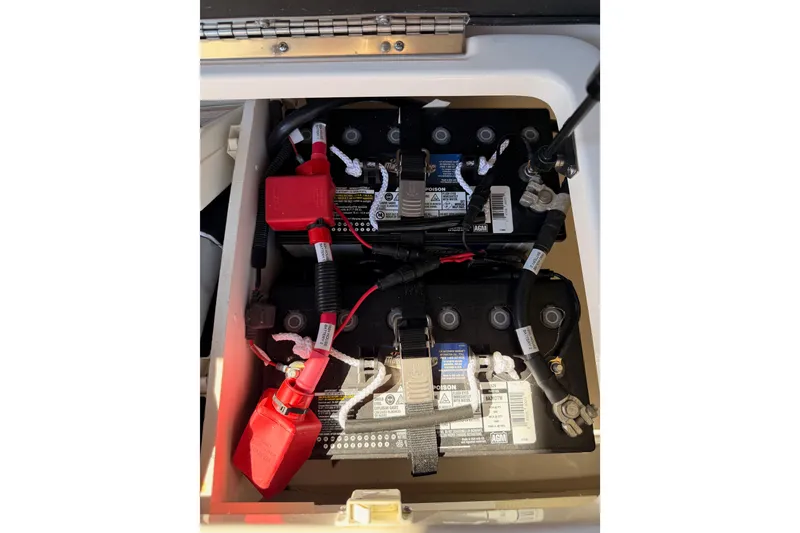 Slide: The Image of 2024 Sea Ray SLX 260 boat battery compartment with wiring and connections. - 54