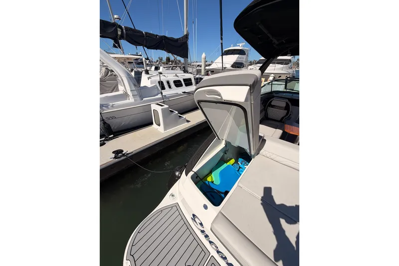 Slide: The Image of 2024 Sea Ray SLX 260 boat docked, open storage compartment, marina background. - 55