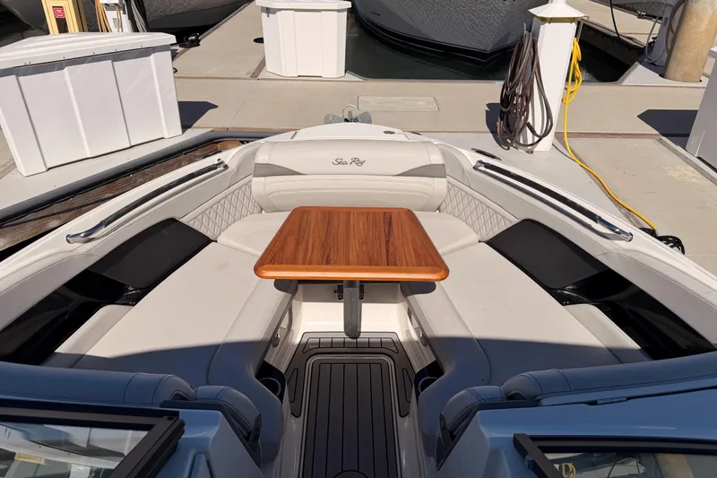 Slide: The Image of 2024 Sea Ray SLX 260 boat interior with elegant seating and wooden table. - 57